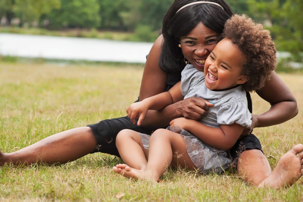 Mom playing with child on grass