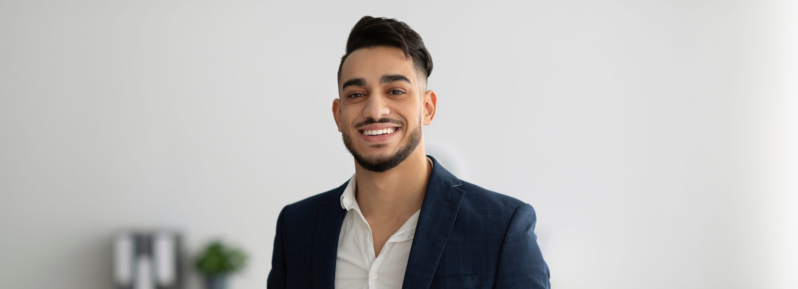 Social Service smiling while holding a clipboard in an office setting.